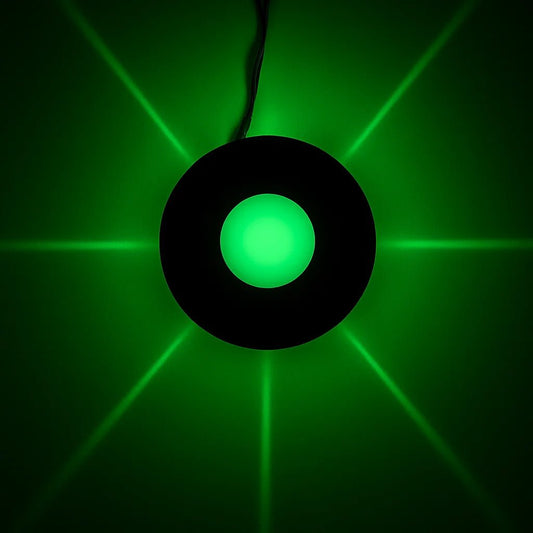 Circular green light with black rim on a dark background