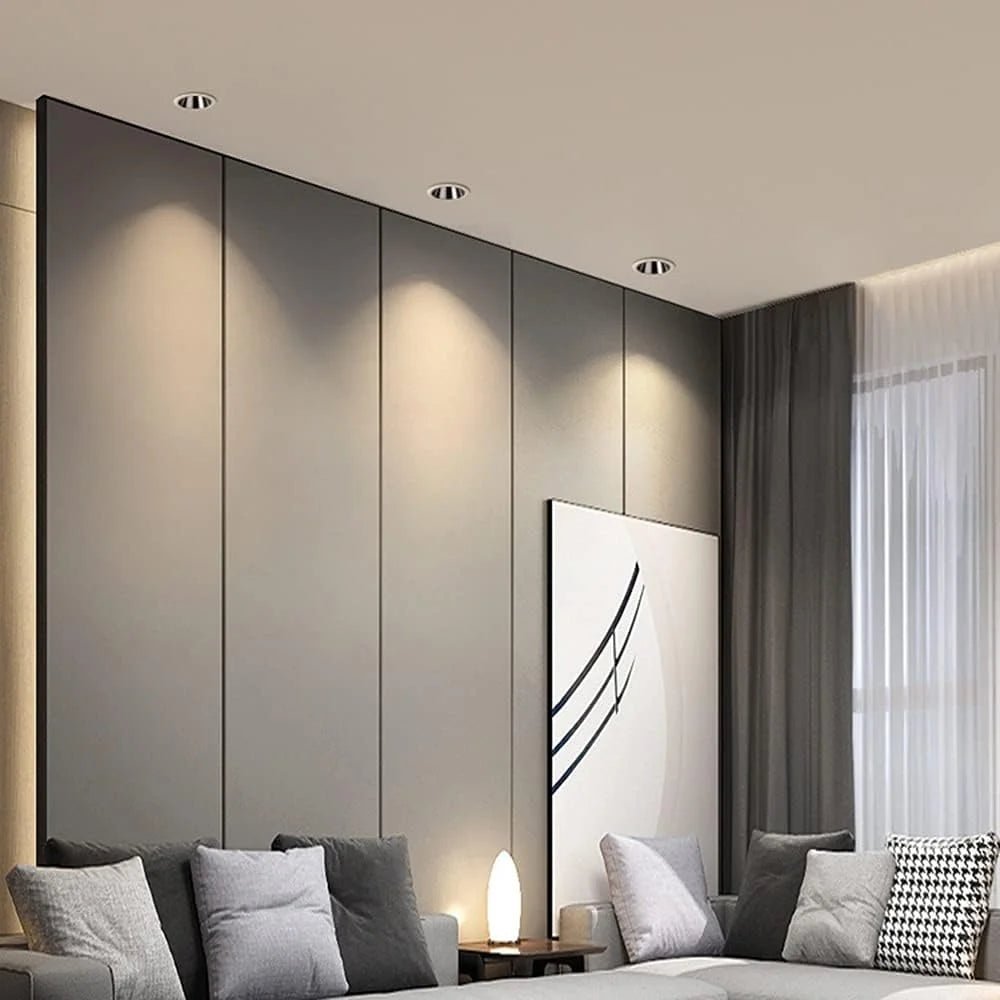 Modern living room with gray walls, a sofa with cushions, and a decorative painting.