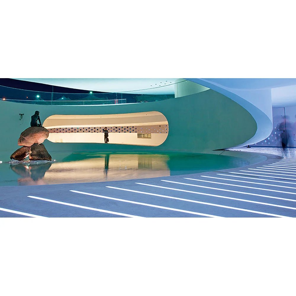 Modern architectural interior with a curved wall and reflective floor.