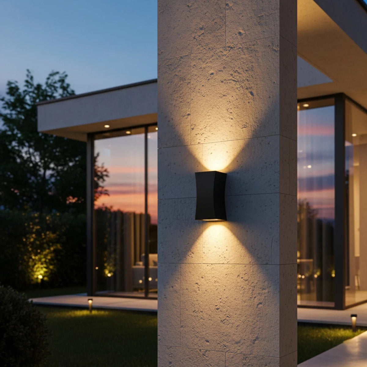 Modern outdoor wall light fixture on a house exterior during dusk.
