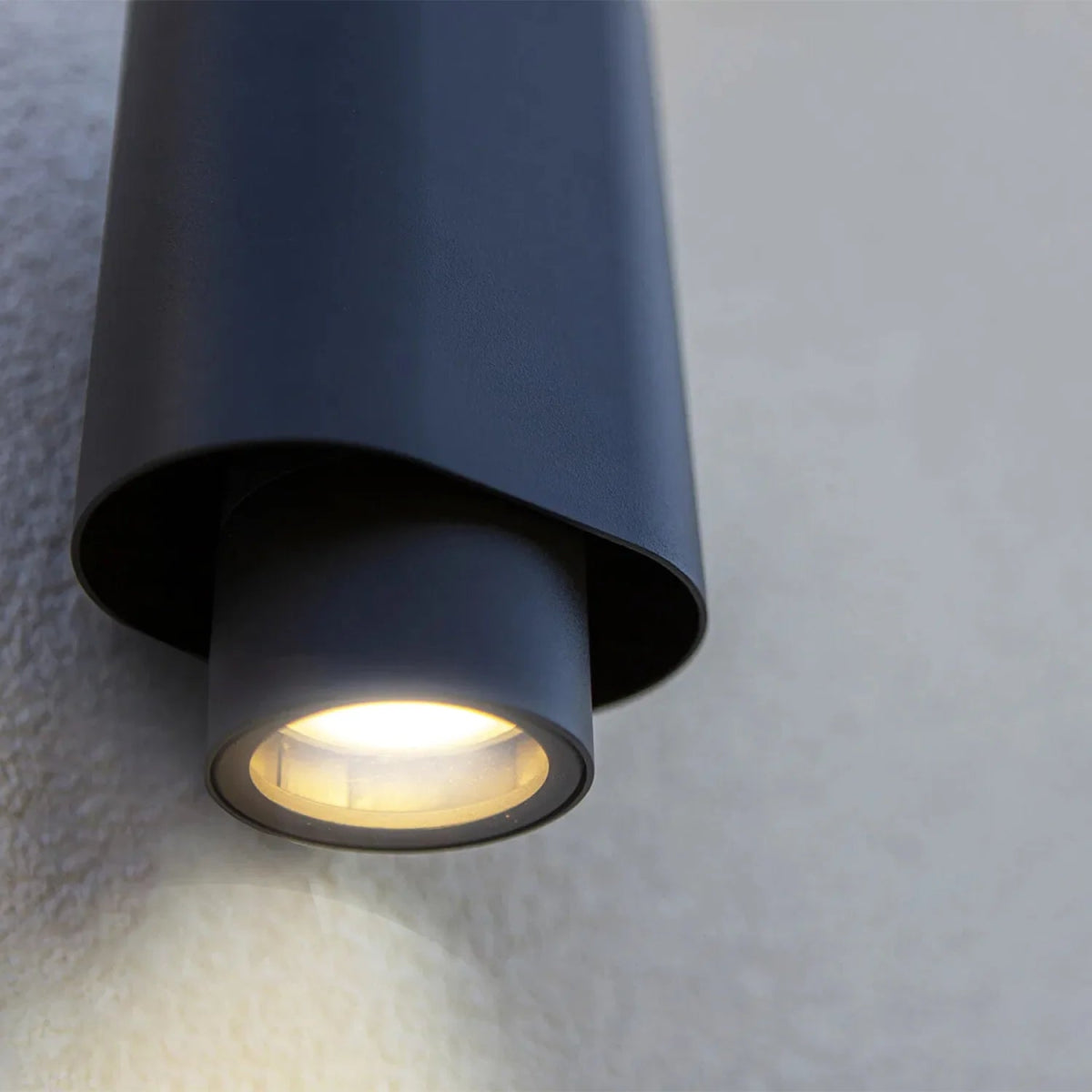 Black outdoor wall light fixture on a textured wall