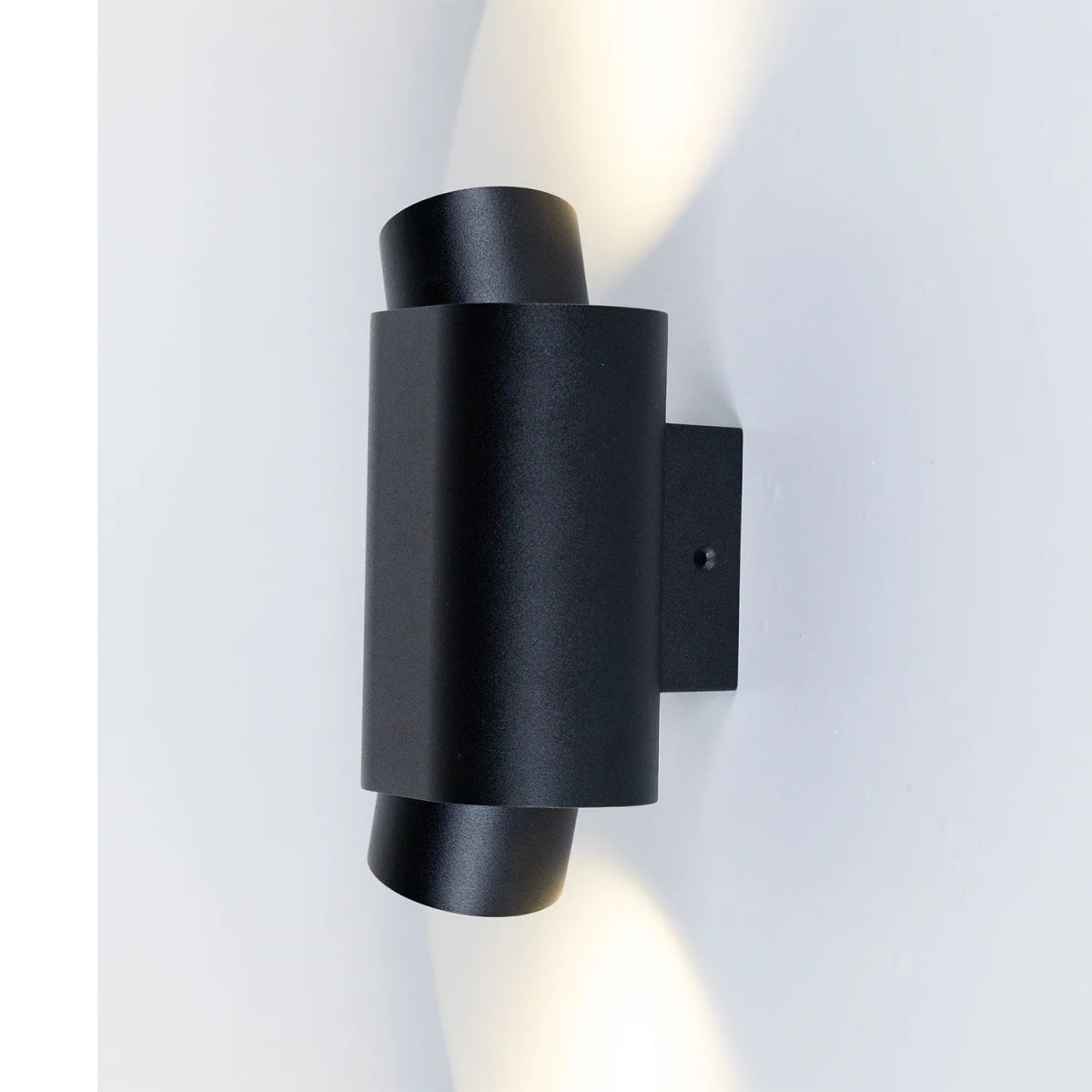 Black wall-mounted light fixture on a white background