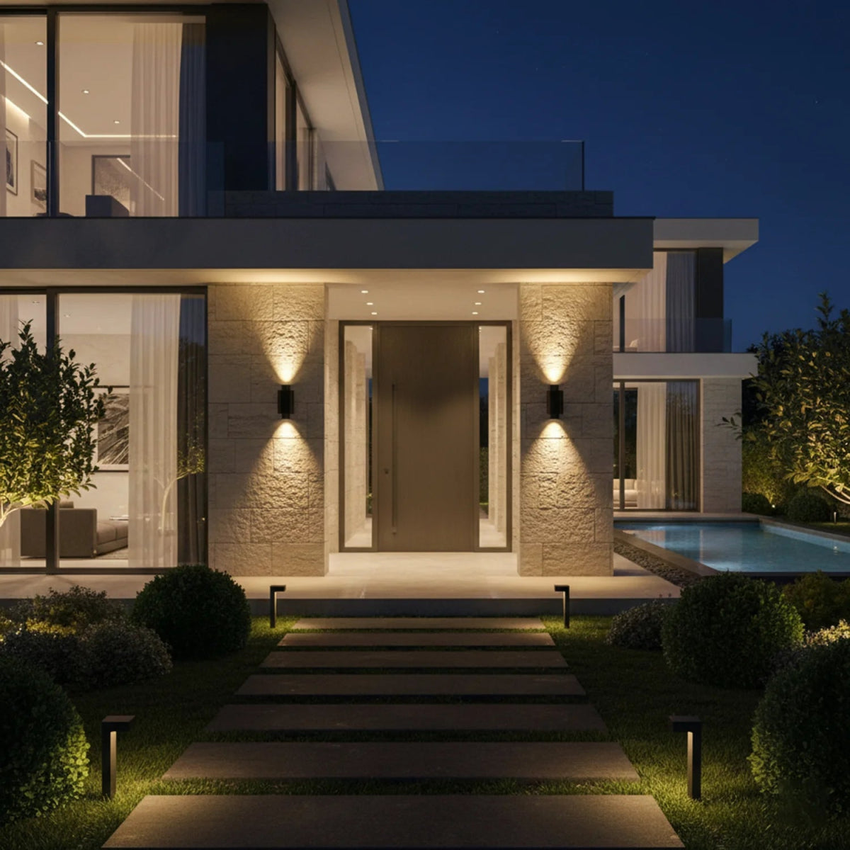 Modern house exterior with illuminated pathway and pool area at night