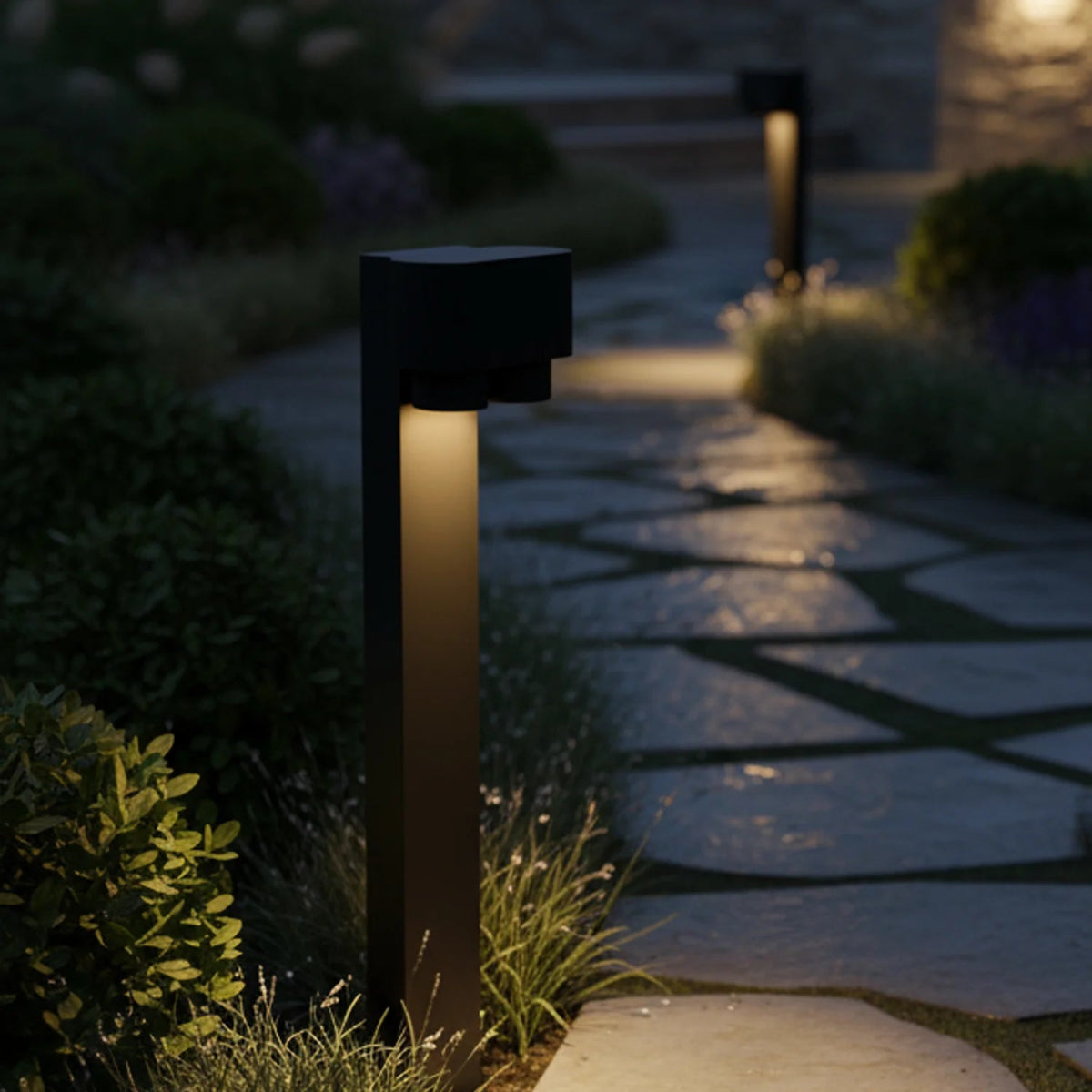 Garden pathway with a illuminated black bollard light