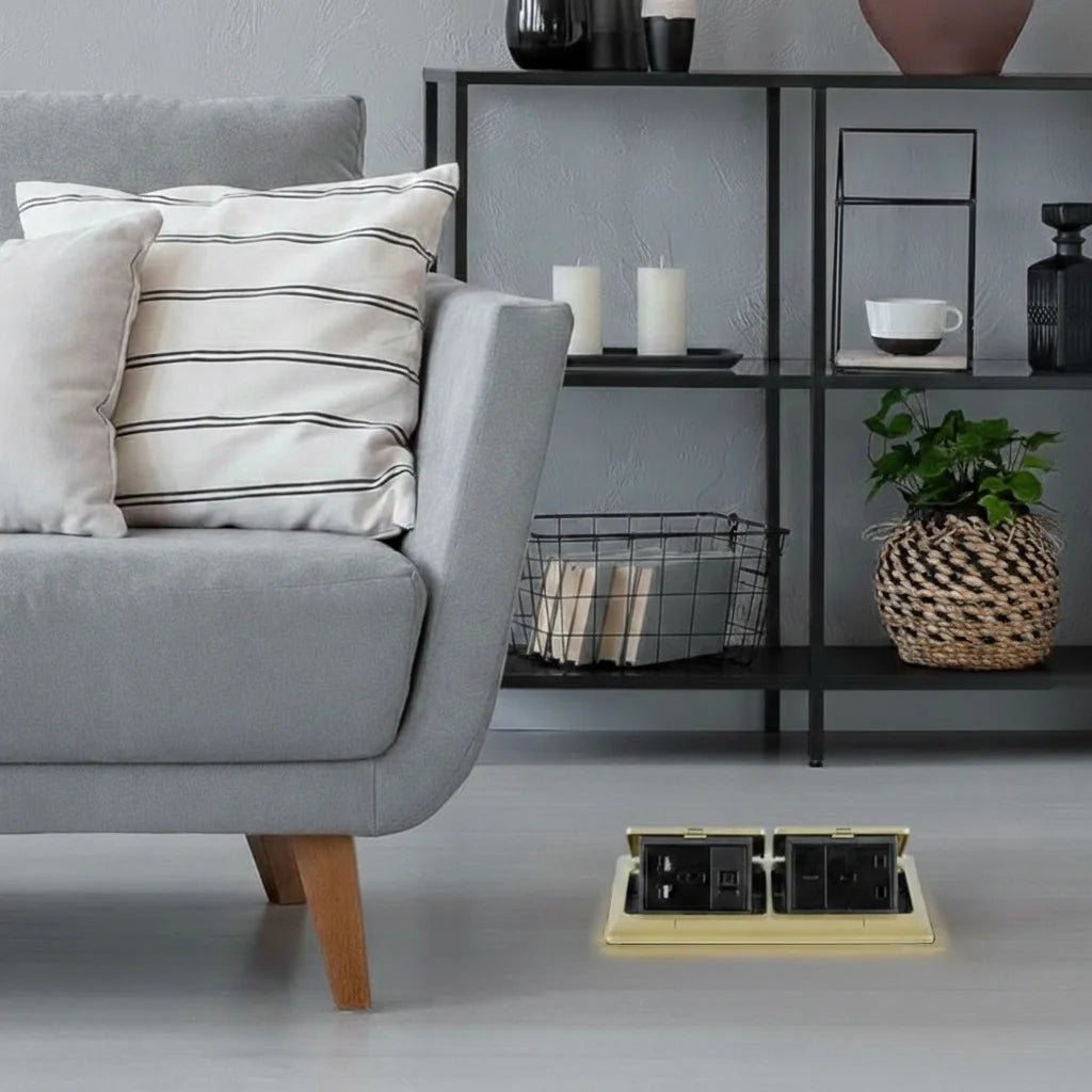 Gray sofa with striped cushions in a living room setting with a power strip on the floor.