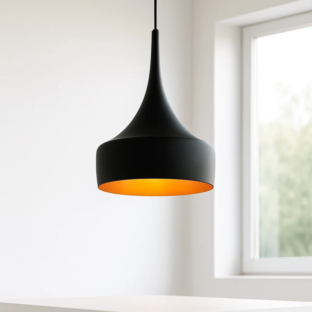 Black pendant light with orange interior hanging in a room with a window.