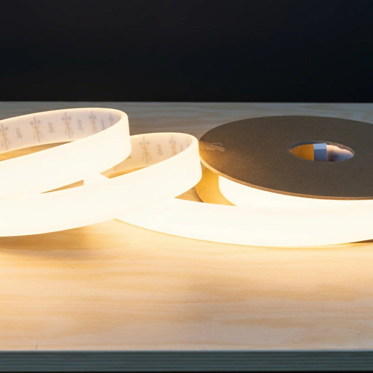 Roll of white tape on a wooden surface with a dark background