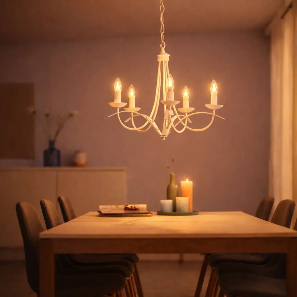 Dining room with a chandelier, table, chairs, and candles creating a warm ambiance.