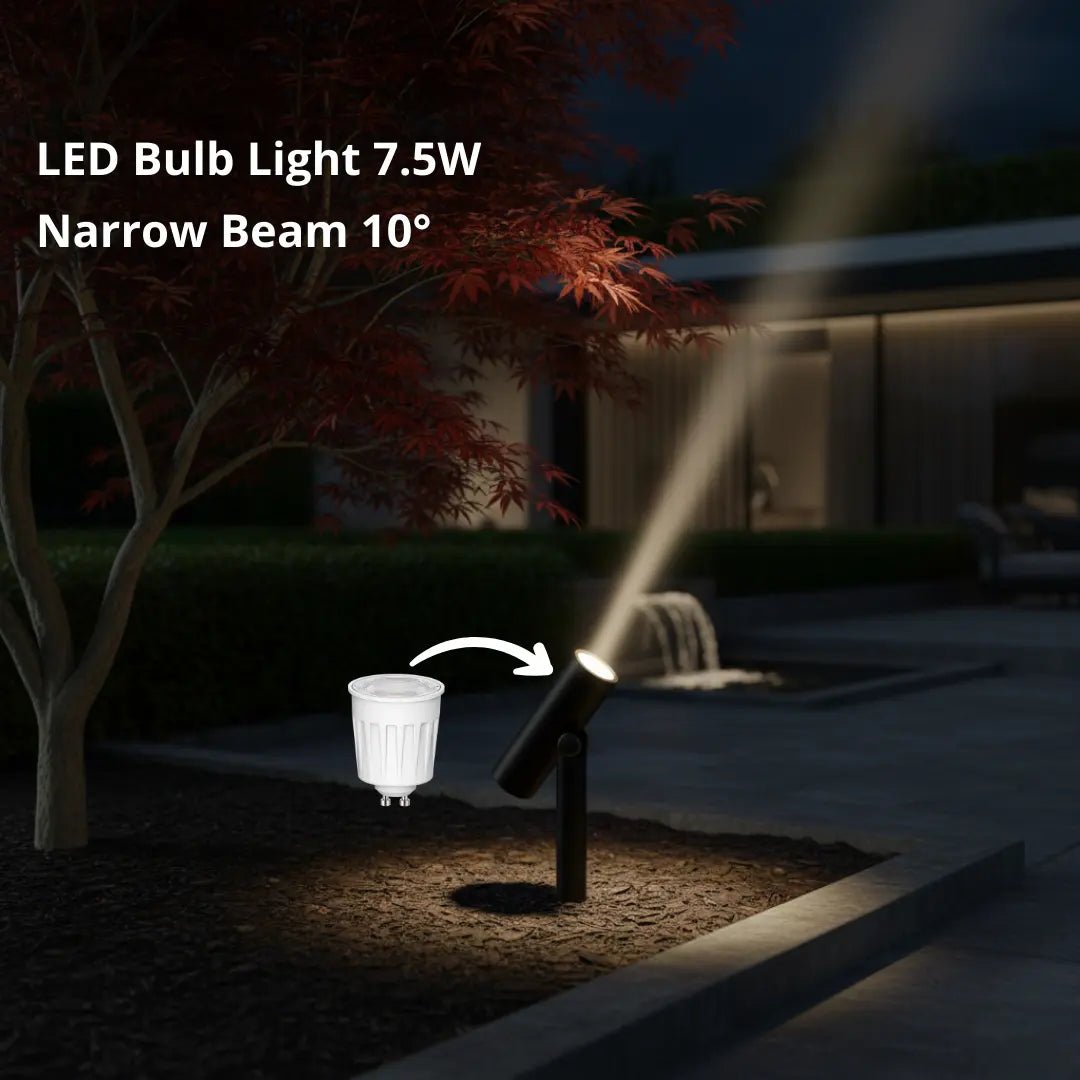 LED bulb light emitting a narrow beam of light in a dark outdoor setting.