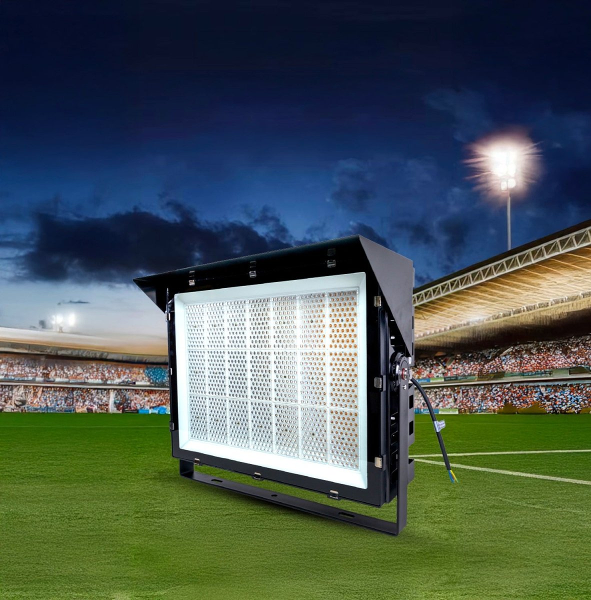 Stadium light fixture on a soccer field with a dark sky and stadium lights in the background