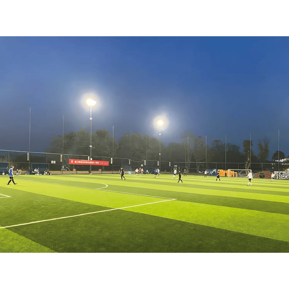 Soccer match on a field at night with artificial lighting
