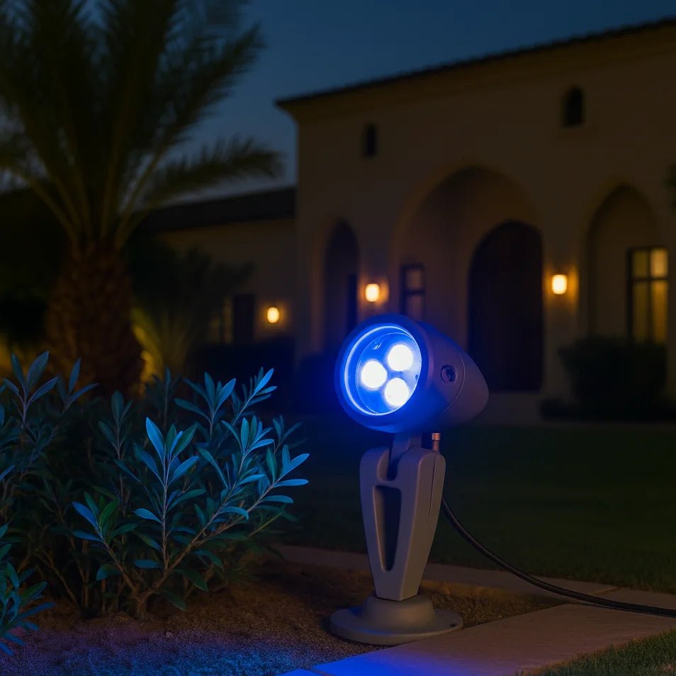 Blue outdoor spotlight on a stand in front of a house at night
