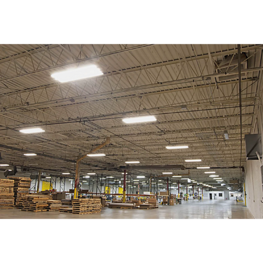 Large warehouse interior with high ceiling and scattered lighting fixtures.