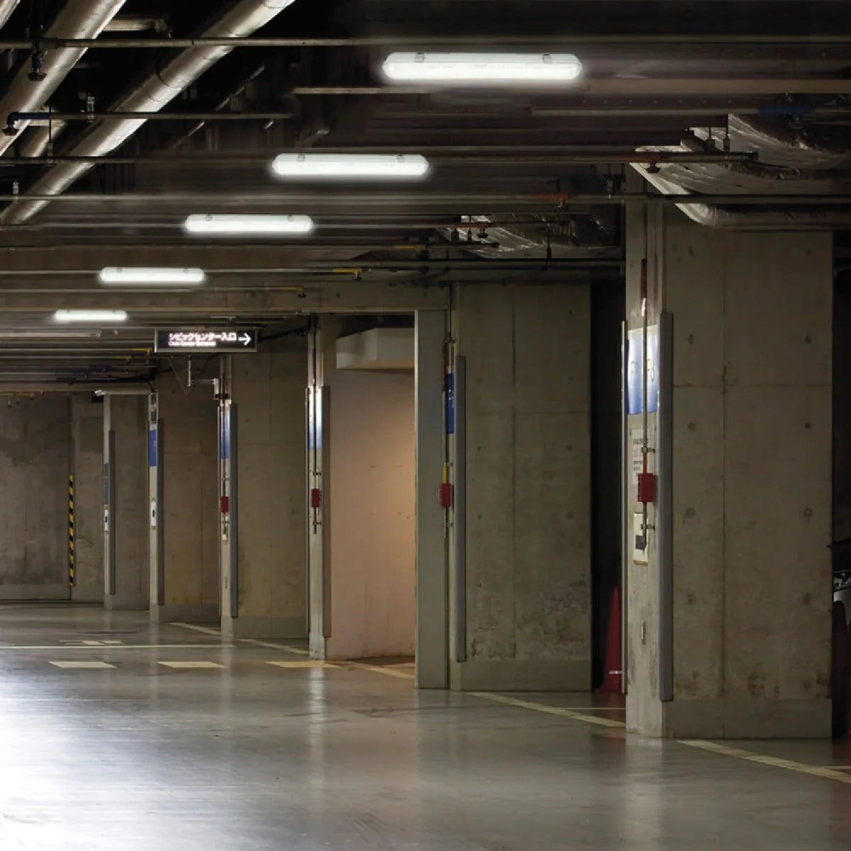Underground parking garage with concrete walls and ceiling lights.