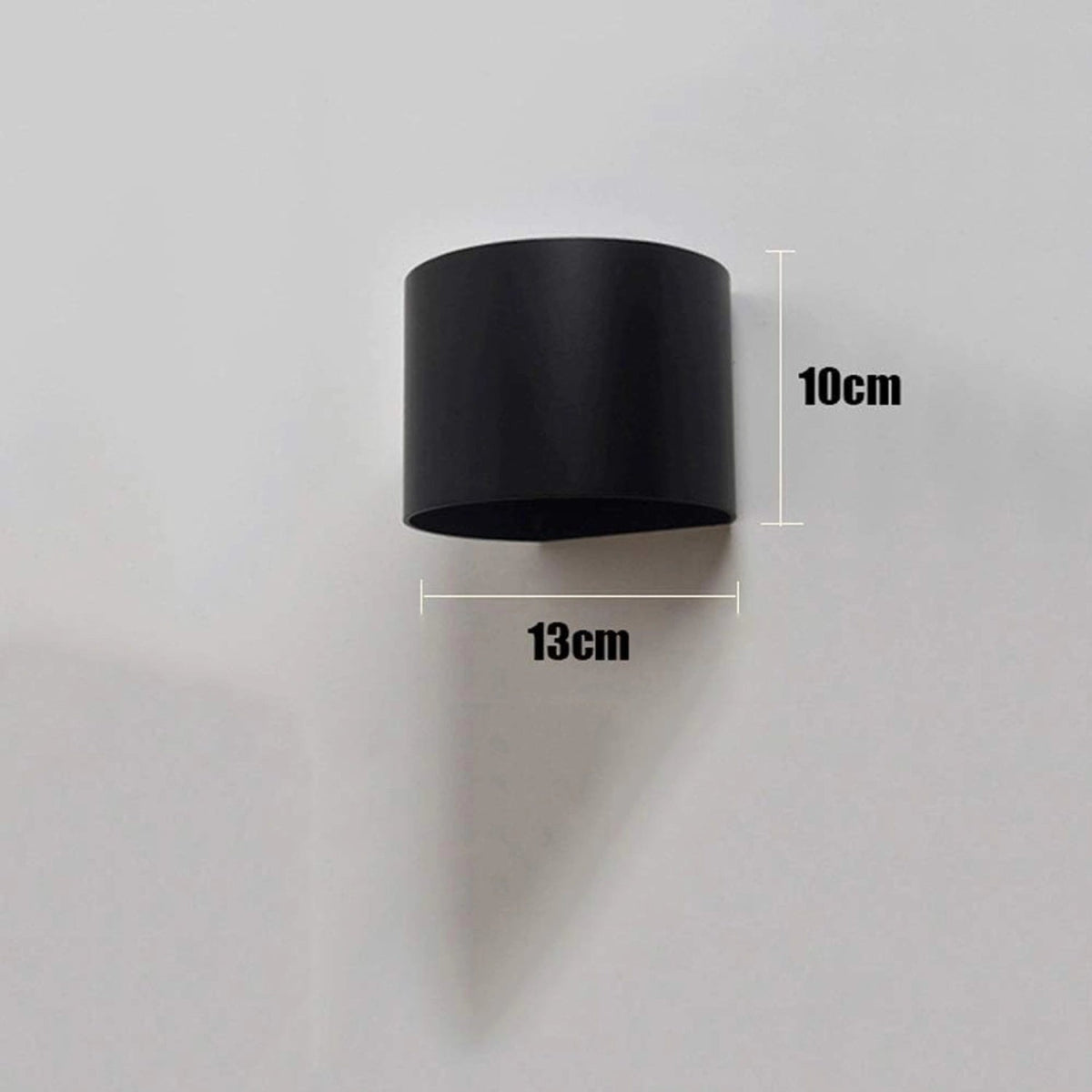 Black cylindrical wall light fixture with measurements on a gray background