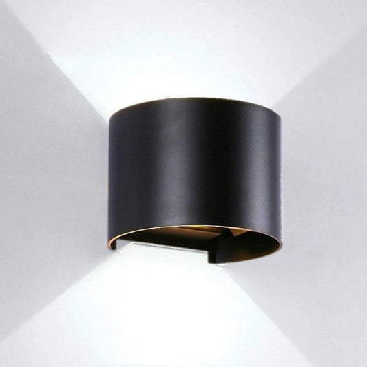 Black cylindrical wall light fixture on a white background