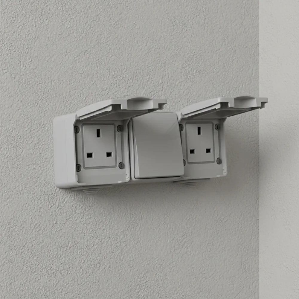 Wall-mounted electrical socket with cover open on a gray wall
