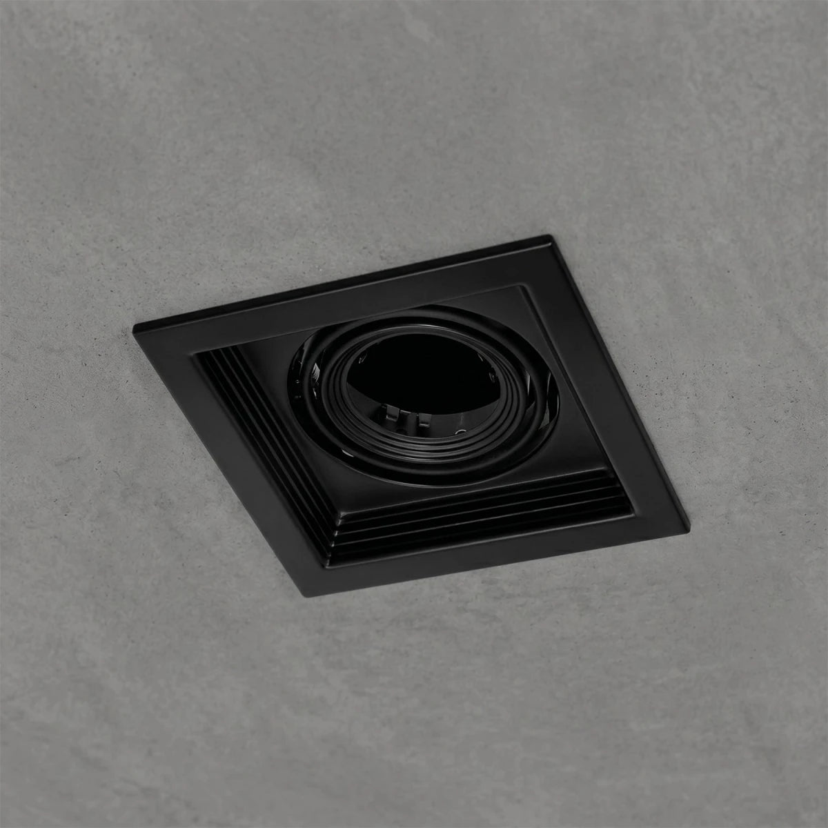 Black square recessed light fixture on a gray concrete background