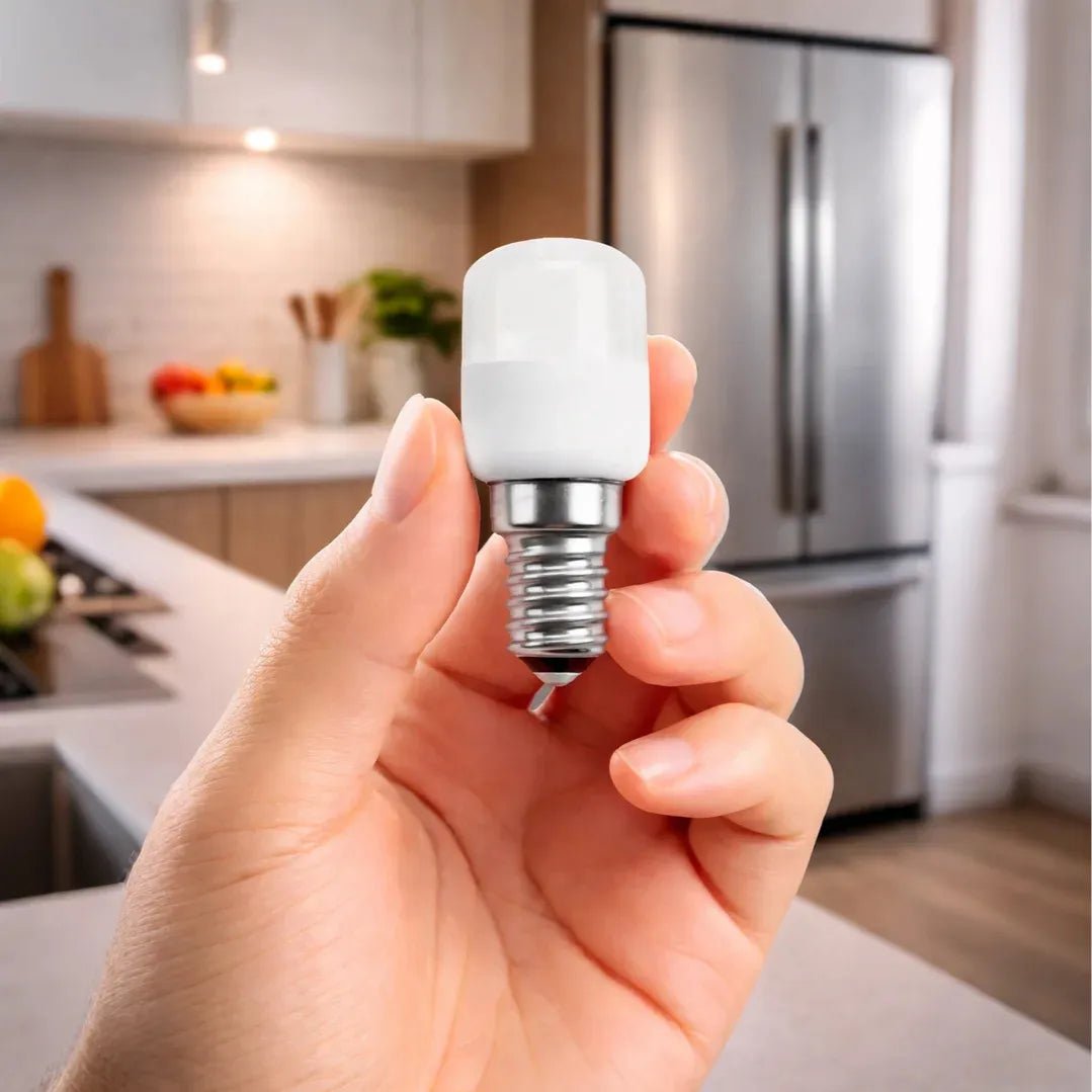 Hand holding a compact fluorescent light bulb in a kitchen setting