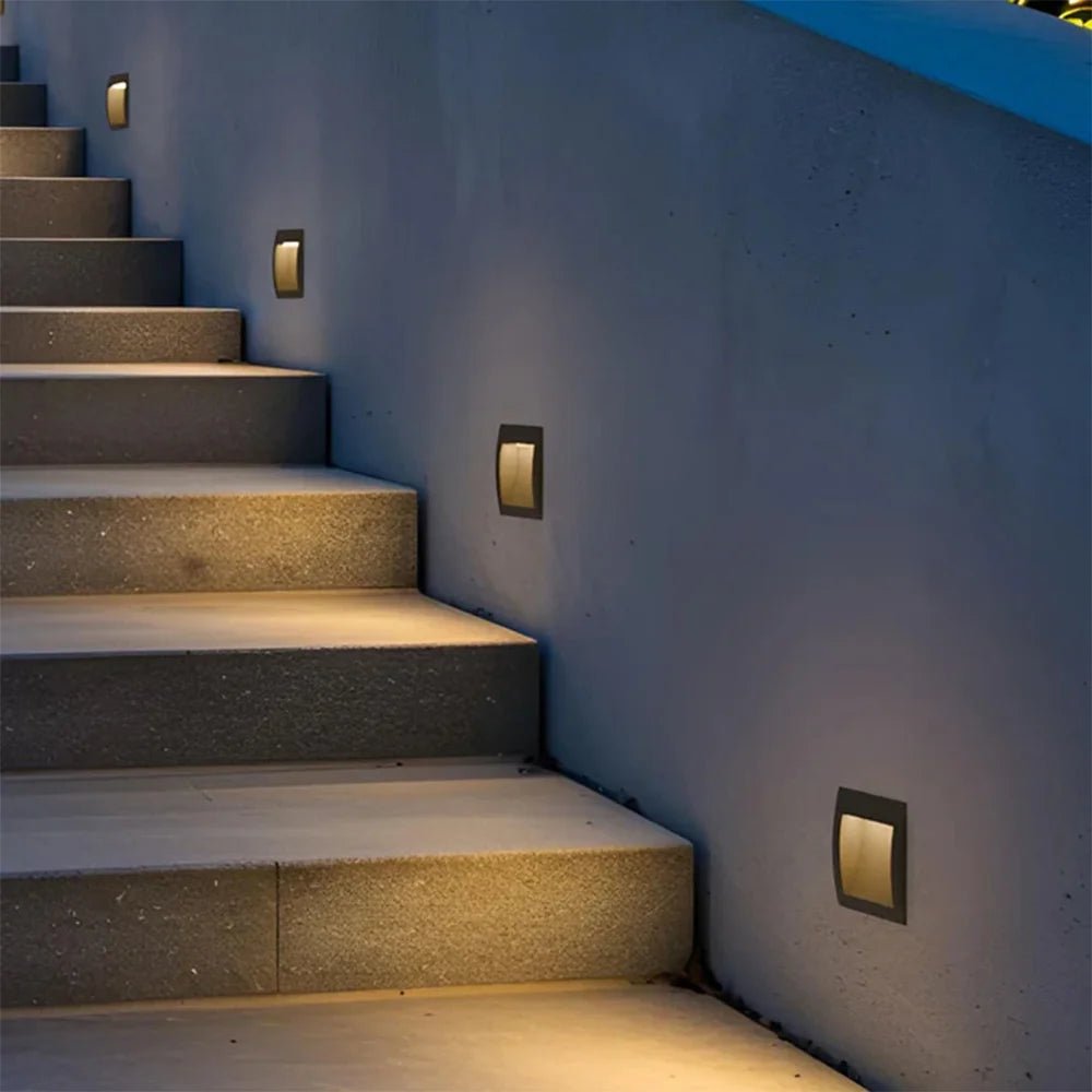 Staircase with wall-mounted lights on a concrete wall