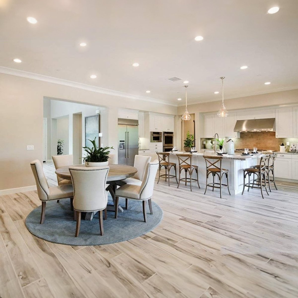 Modern kitchen and dining area with wooden flooring and white walls.