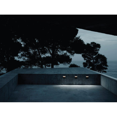 Ultralight Modern Wall Light (FYL0003) illuminating an outdoor concrete seating area at dusk with soft LED light.