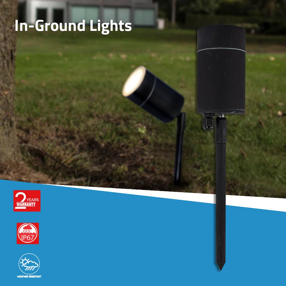 In-ground outdoor light fixture on grass with warranty and IP rating icons displayed.