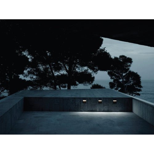 Ultralight Modern Wall Light (FYL0003) illuminating an outdoor concrete seating area at dusk with soft LED light.
